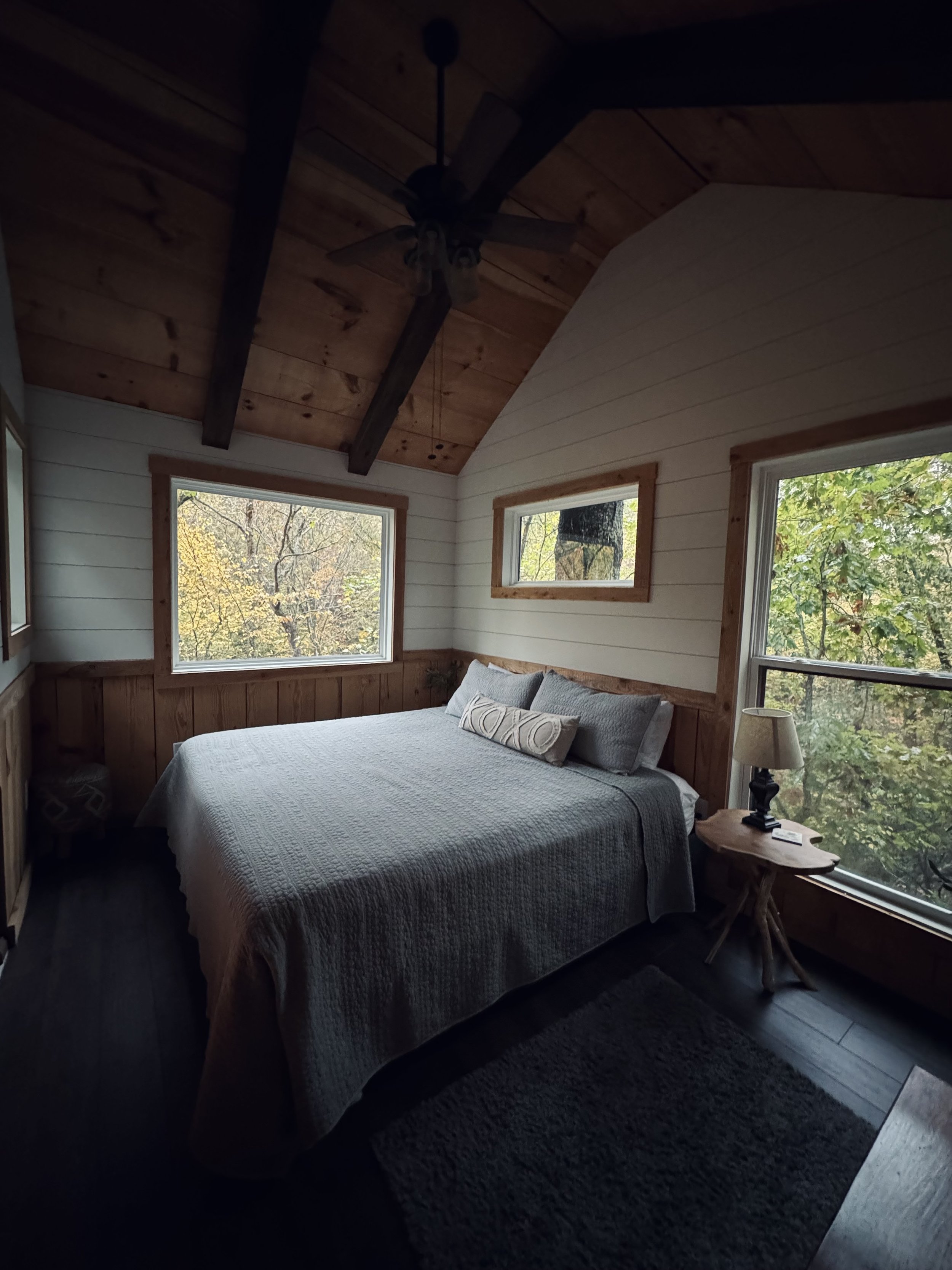 Guest-ready bedroom with clean white linens and forest views